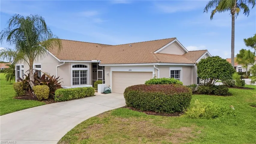 View of front of home featuring stucco siding, an attached garage, a front lawn, and driveway
