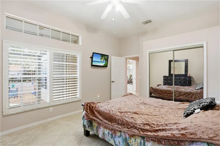 Bedroom featuring a closet, a ceiling fan, and light tile patterned floors