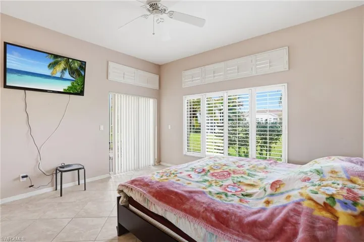 Bedroom with access to exterior, light tile patterned flooring, and a ceiling fan