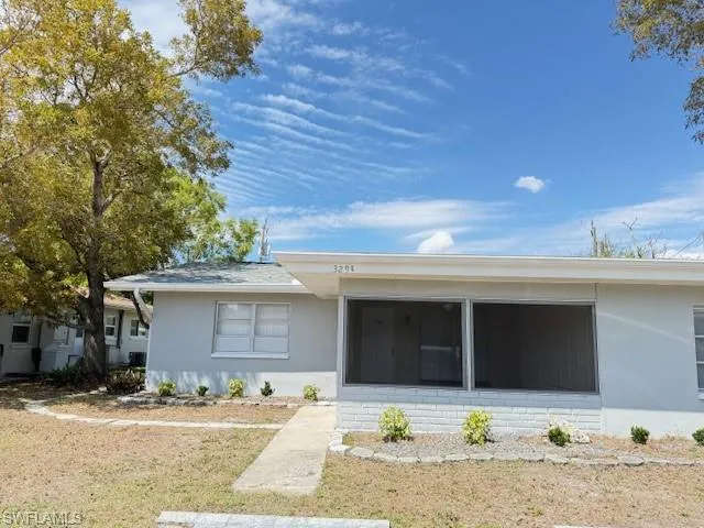 View of front of property with stucco siding and a front lawn