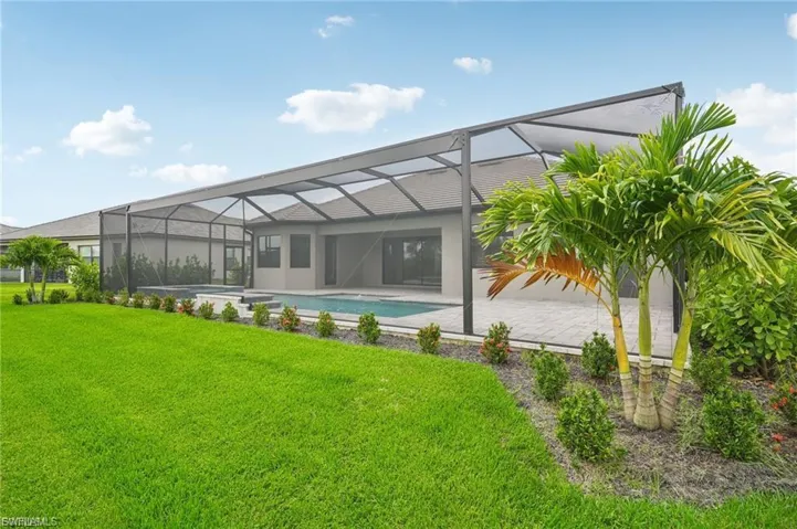 Rear view of house with a sunroom, an outdoor pool, a lanai, and a patio area