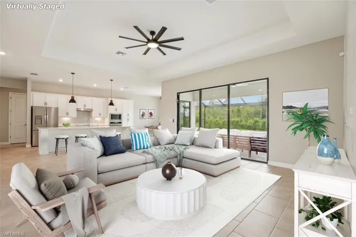 Living area featuring a raised ceiling, a ceiling fan, recessed lighting, and light tile patterned flooring
