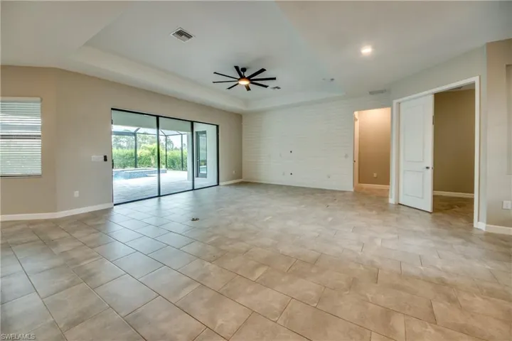Spare room with a raised ceiling and a ceiling fan