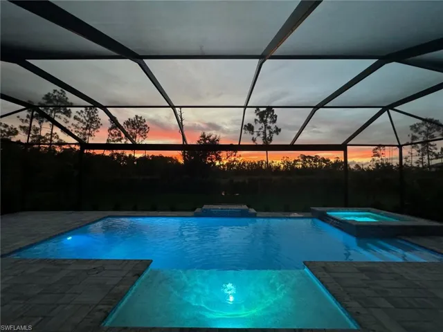 View of swimming pool with a pool with connected hot tub, glass enclosure, a sunroom, and a patio area