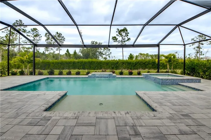 View of pool with a sunroom, a lanai, a patio area, and a pool with connected hot tub