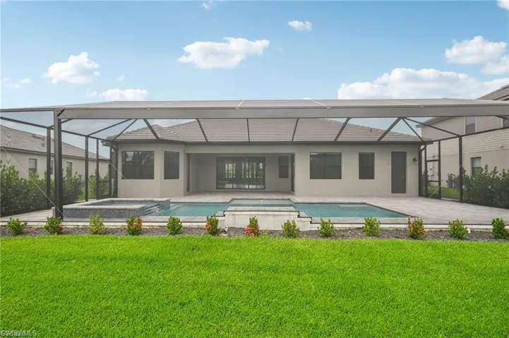 Back of house with a sunroom, a yard, a patio area, and a lanai