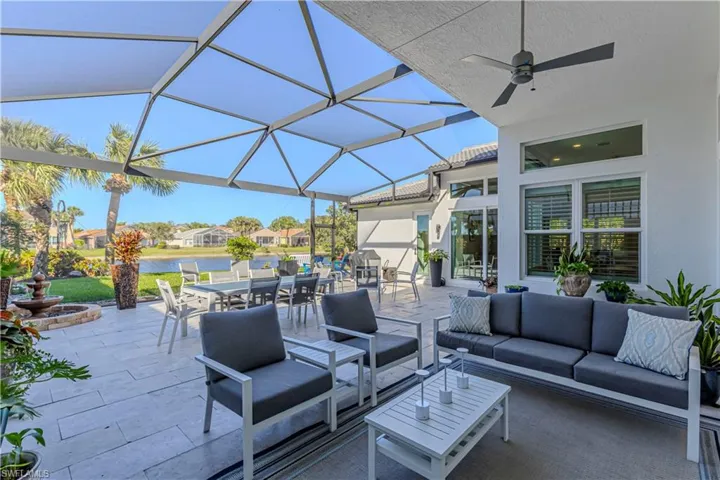 View of patio featuring an outdoor living space, outdoor dining area, a water view, ceiling fan, and a lanai