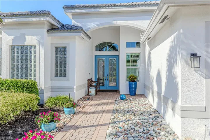 Property entrance featuring french doors, stucco siding, and a tiled roof