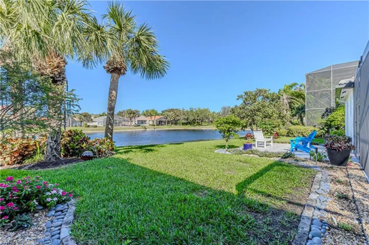 View of grassy yard with a water view and a lanai