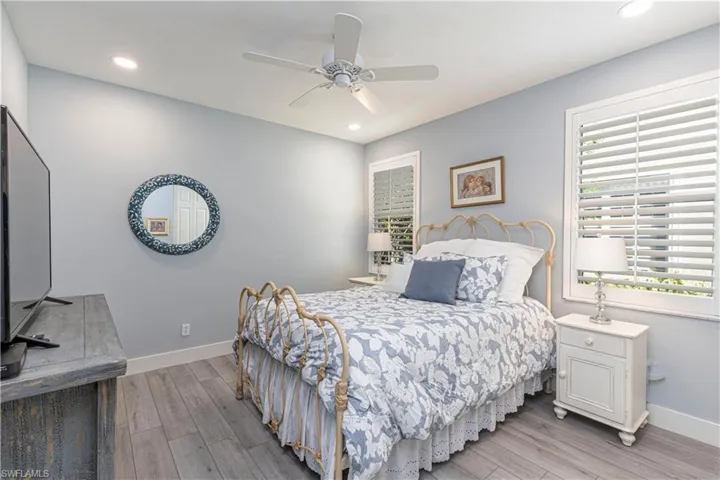 Bedroom with light wood finished floors, baseboards, recessed lighting, and ceiling fan