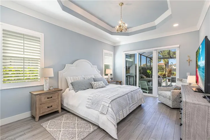 Bedroom with access to outside, a chandelier, multiple windows, light wood-type flooring, and recessed lighting