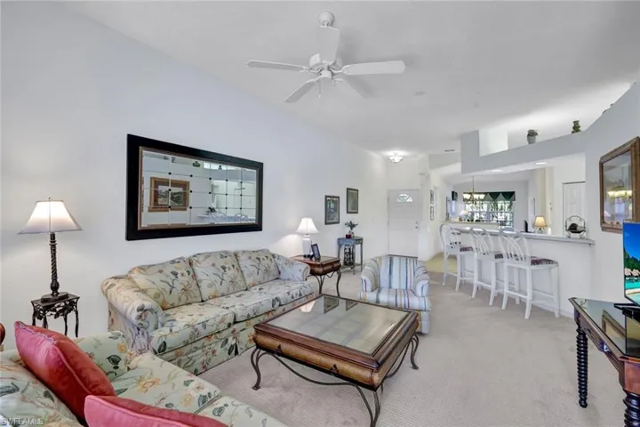 Living area with light carpet and a ceiling fan