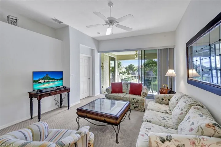Living area featuring ceiling fan and carpet flooring