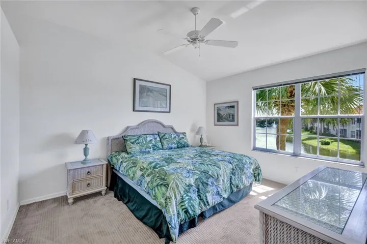 Carpeted bedroom with lofted ceiling and ceiling fan