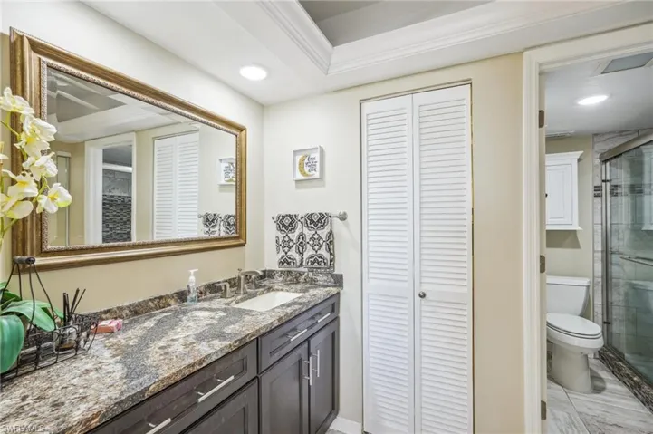 Bathroom with vanity, toilet, and a shower with door