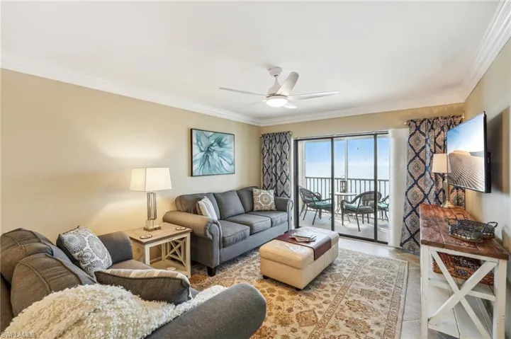 Living room featuring ceiling fan and ornamental molding