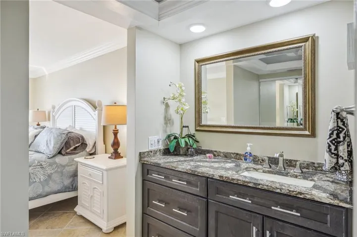 Bathroom featuring tile patterned flooring, vanity, and crown molding