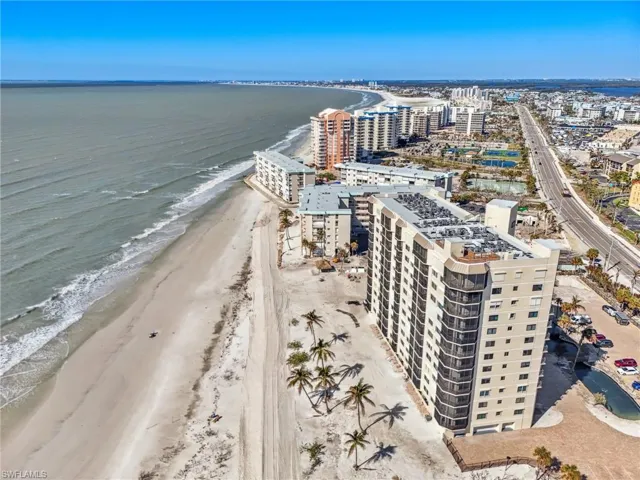 Birds eye view of property with a view of the beach and a water view