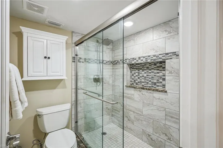 Bathroom featuring toilet and an enclosed shower