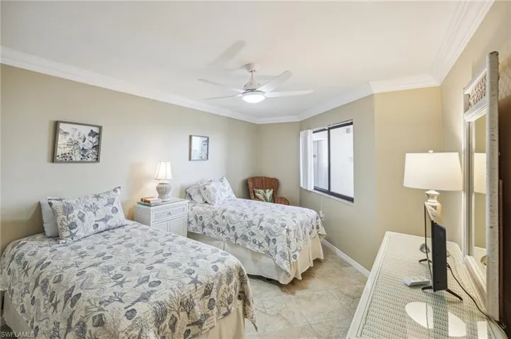 Bedroom with ceiling fan and crown molding