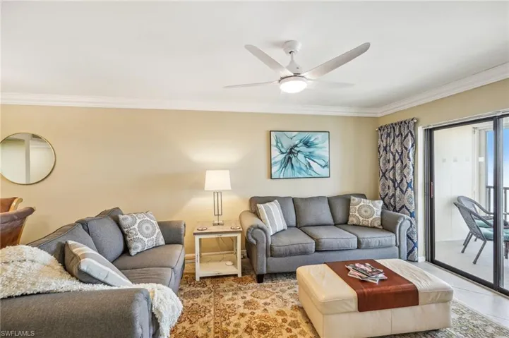 Living room with ceiling fan and ornamental molding