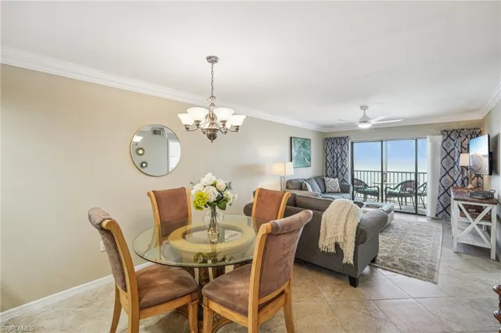 Dining space featuring ceiling fan with notable chandelier and ornamental molding