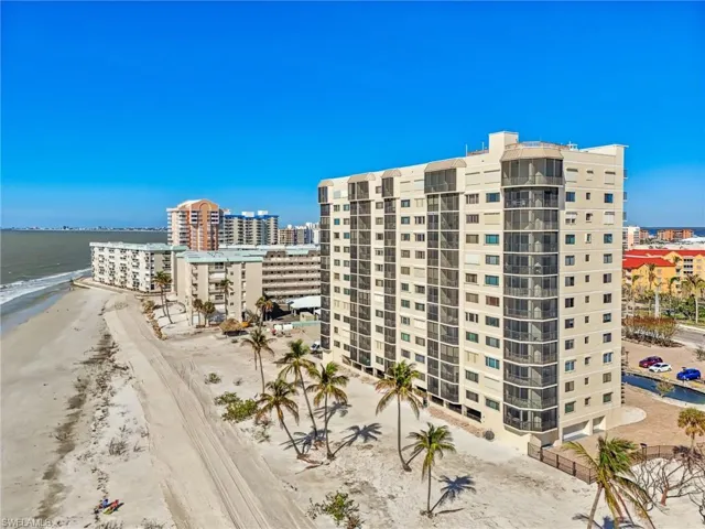 View of property with a water view and a view of the beach