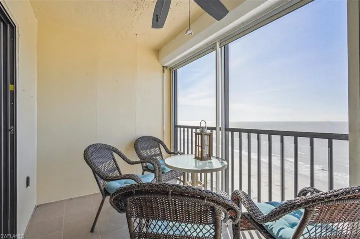Sunroom / solarium featuring ceiling fan and a water view
