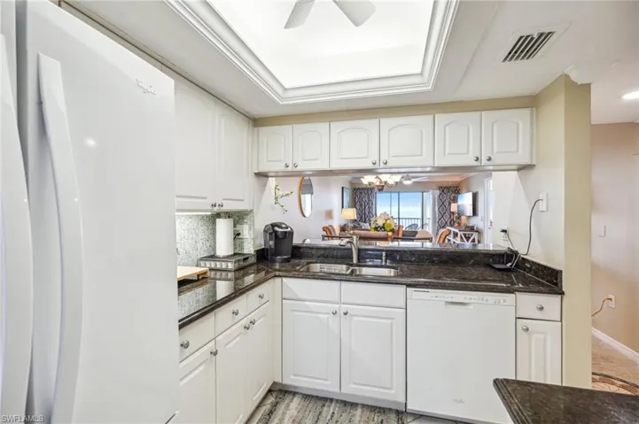 Kitchen featuring ceiling fan, sink, white cabinets, and white appliances