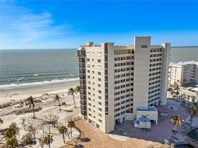 View of building exterior with a water view and a view of the beach