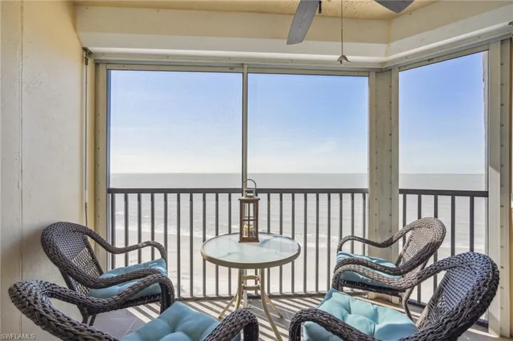 Sunroom with ceiling fan and a water view
