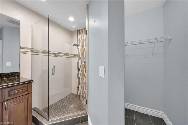 Bathroom with a shower stall, vanity, recessed lighting, and wood tiled floors