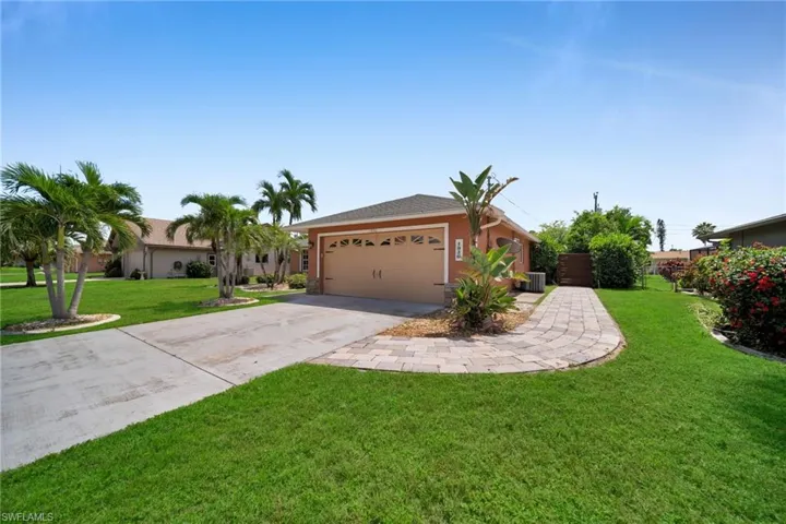 Ranch-style home with a front yard, concrete driveway, an attached garage, and stucco siding
