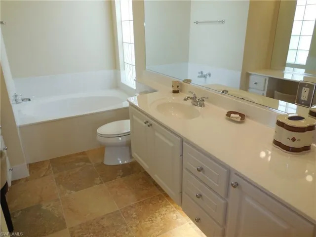 Bathroom with tile patterned flooring, a bath, toilet, and vanity