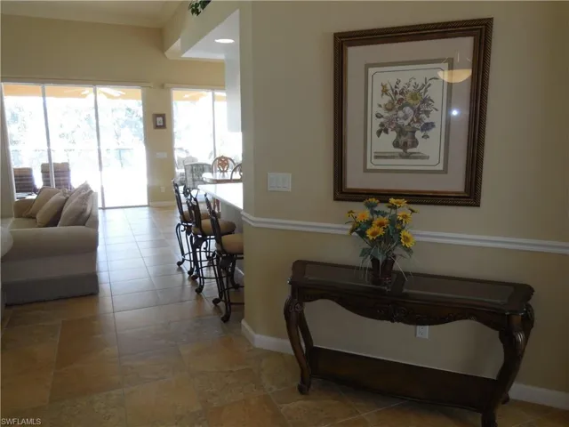 Corridor with crown molding and tile patterned floors