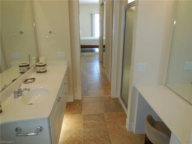 Bathroom with vanity, a shower with door, and tile patterned flooring