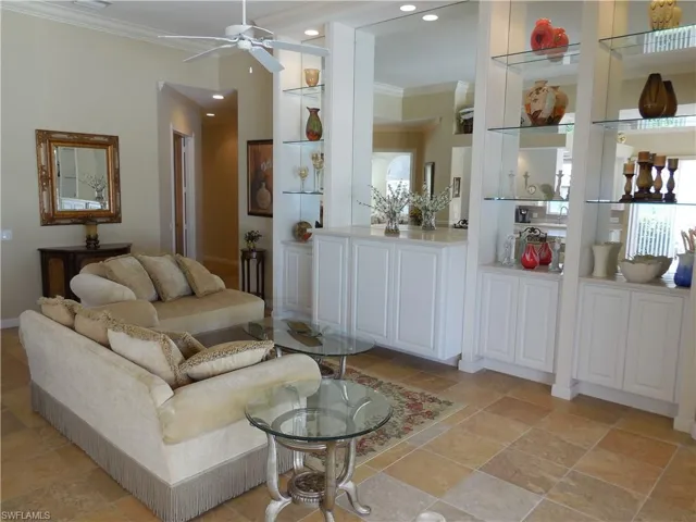 Tiled living room featuring crown molding and ceiling fan