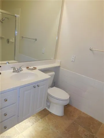 Bathroom featuring tile patterned flooring, toilet, and vanity