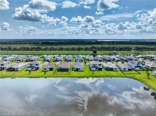 Waterfront community featuring single-family residences with light-colored exteriors and dark roofing