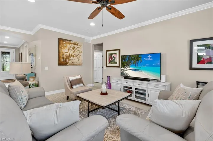 Living area with crown molding, light wood-style floors, recessed lighting, and a ceiling fan