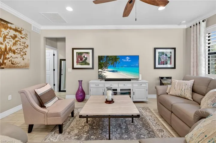 Living area with ornamental molding, light wood-style flooring, recessed lighting, and a ceiling fan