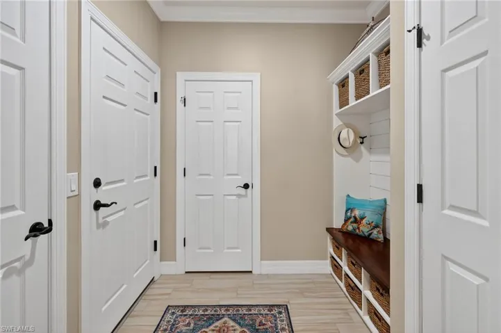 Mudroom featuring light wood-type flooring and crown molding