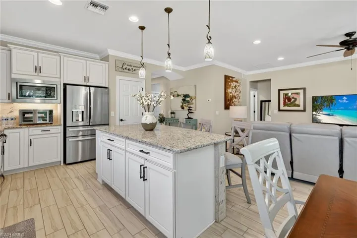 Kitchen featuring open floor plan, stainless steel appliances, decorative light fixtures, recessed lighting, and a center island