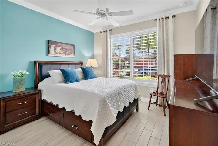 Bedroom with ornamental molding, light wood-type flooring, and ceiling fan