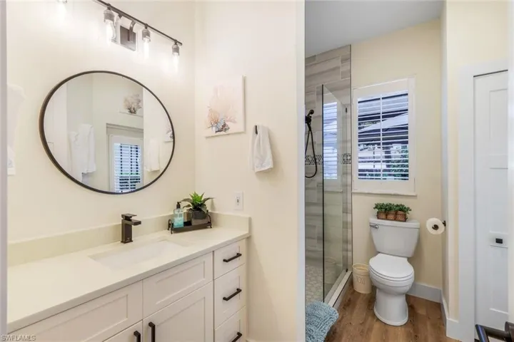 Guest Bathroom with walk in shower, vanity + door to pool deck for easy access