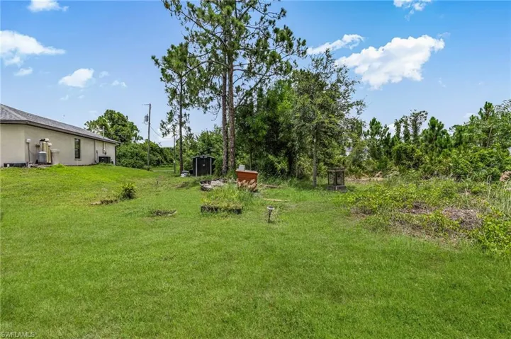 View of grassy yard featuring a shed
