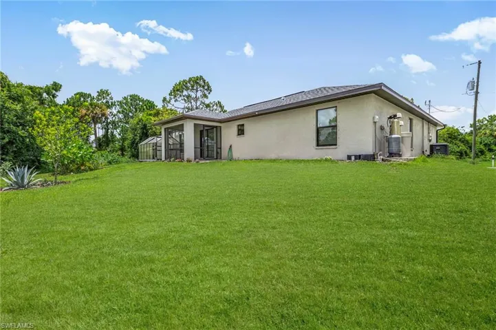 Back of property featuring stucco siding and a yard