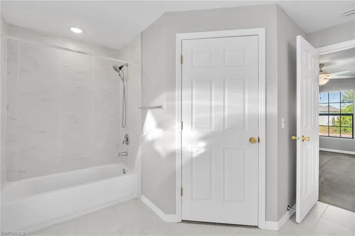 Full bath featuring marble finish floor, recessed lighting, tub / shower combination, baseboards, and ceiling fan