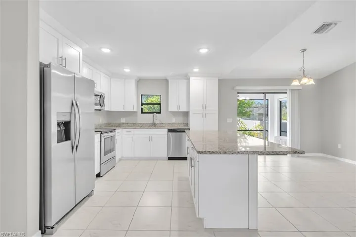 Kitchen featuring stainless steel appliances, plenty of natural light, a kitchen island, and visible vents