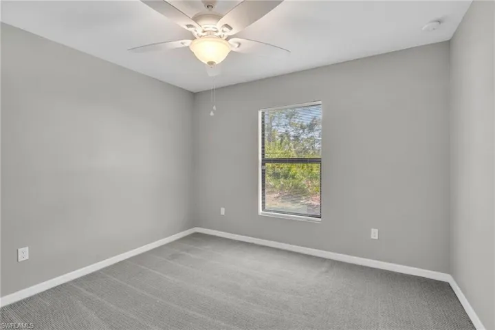 Unfurnished room featuring baseboards, ceiling fan, and carpet flooring